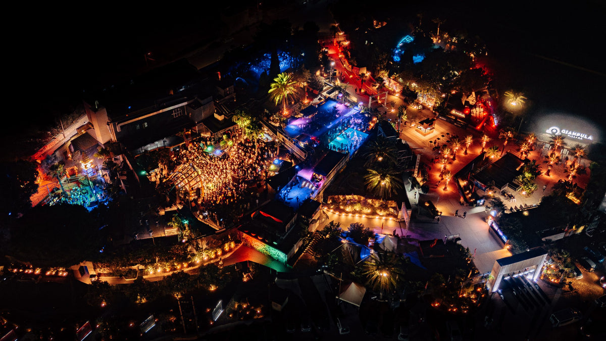 Gianpula Village vanuit de lucht bij nacht: het verlichte clubcomplex tussen de palmen, op het platteland bij Rabat
