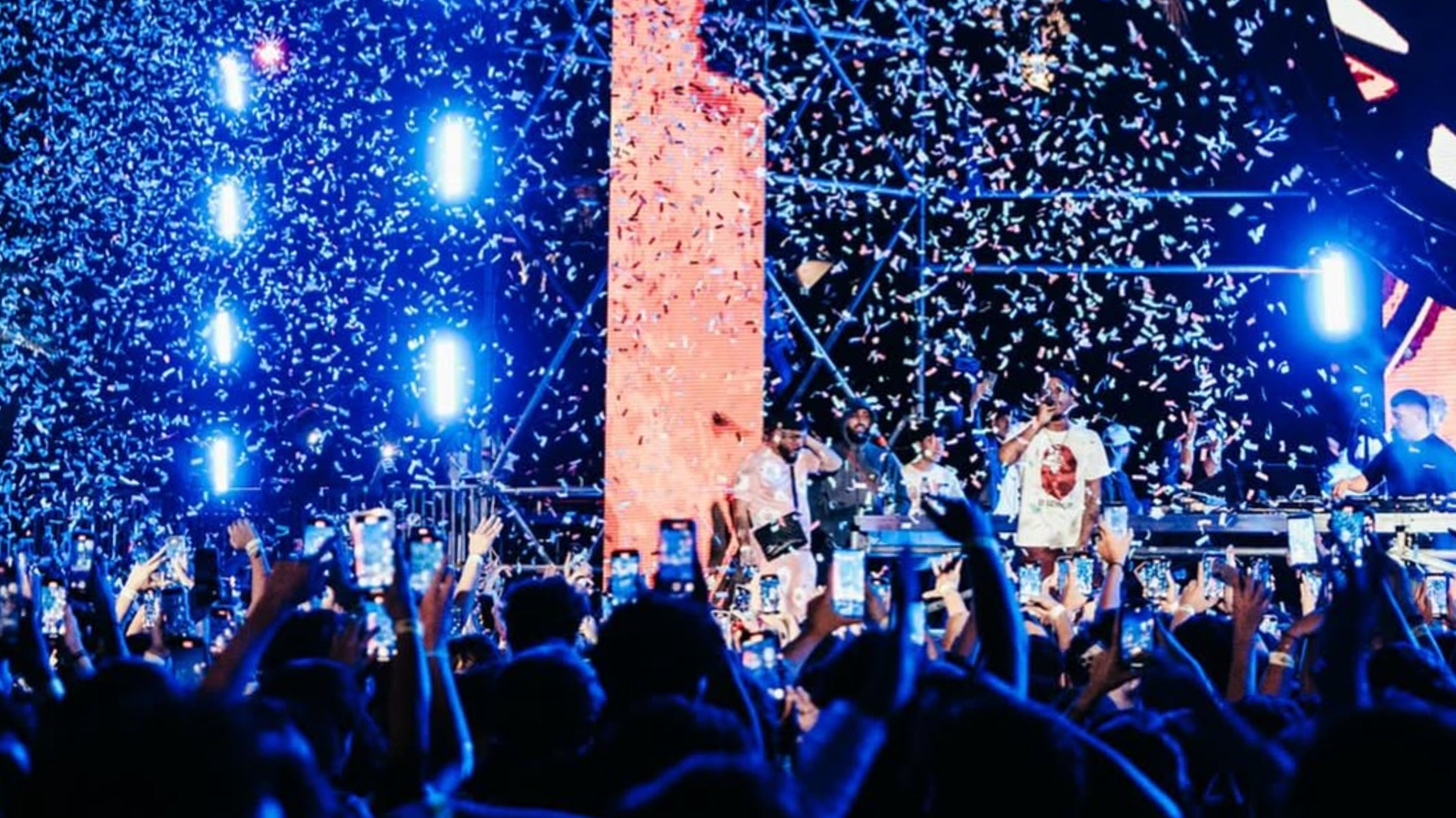 Concert scene with a crowd and stage lights amidst falling confetti