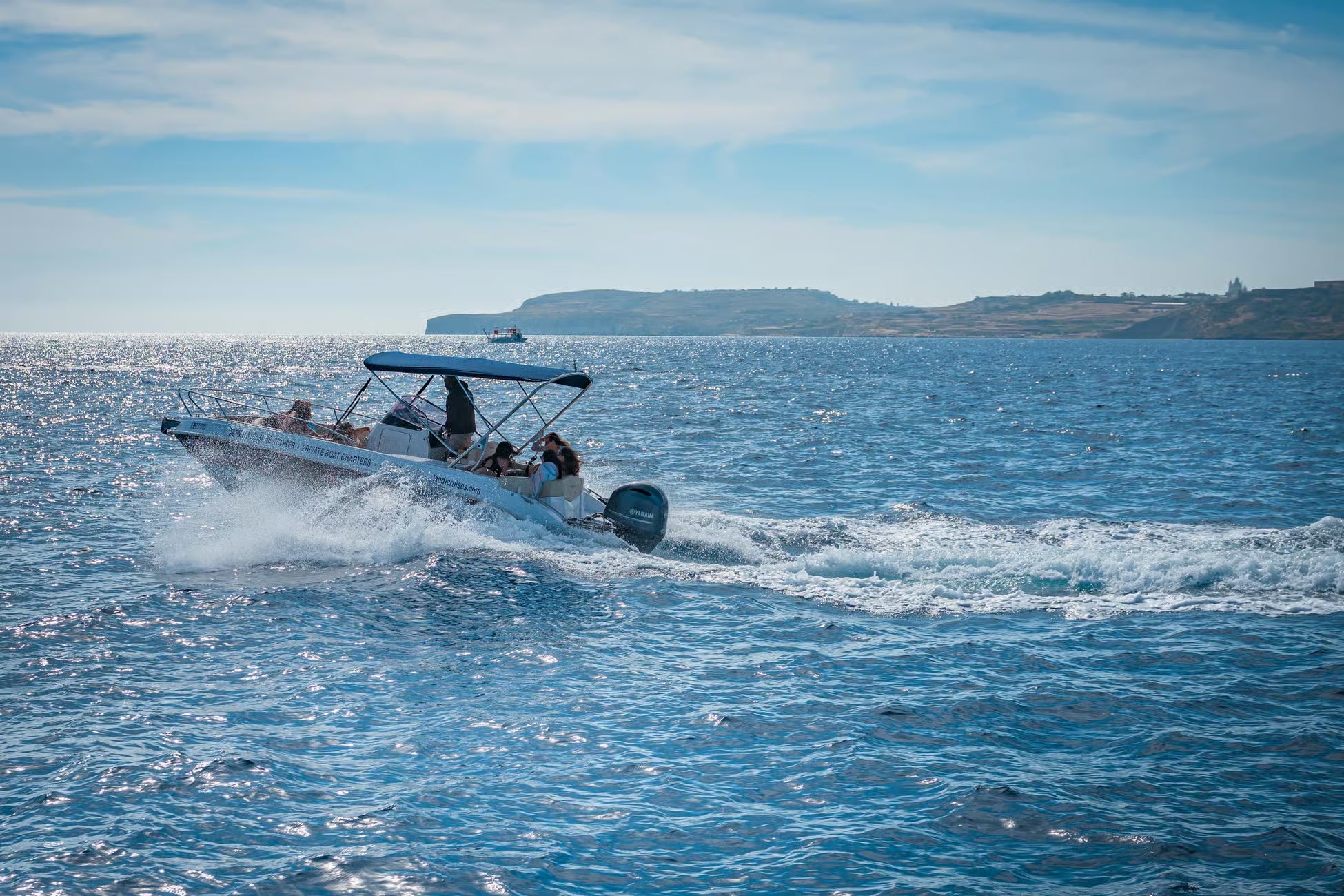 Boat with people on a body of water under a clear sky