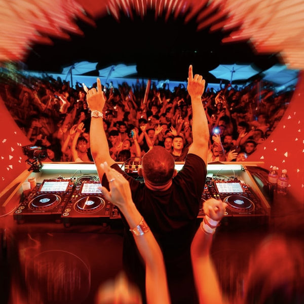 DJ con le braccia alzate davanti a una folla al Café del Mar Malta
