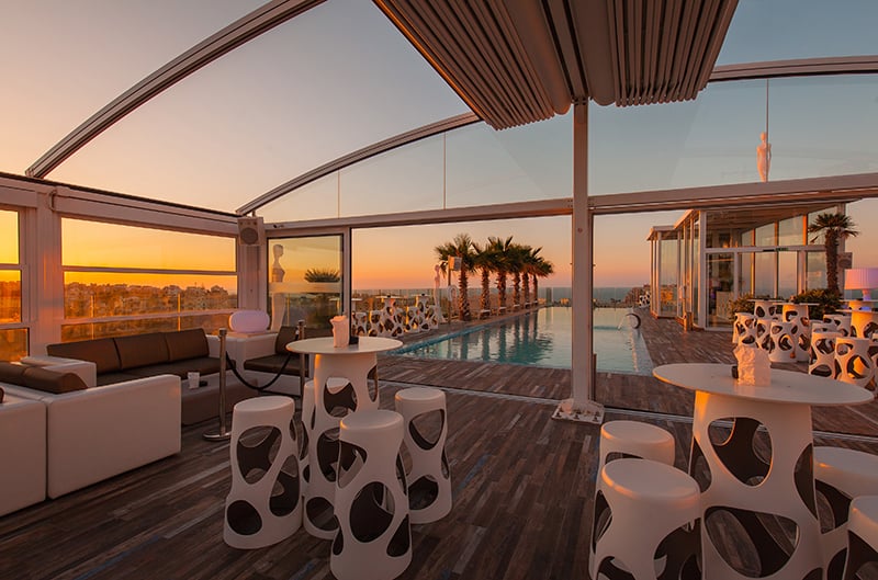 La terraza de la azotea de Infinity by Hugo's al atardecer, con el techo retráctil