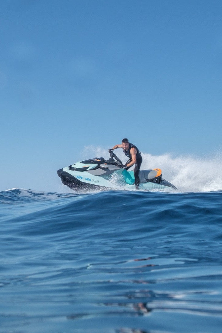 Person riding a jet ski on a clear blue day