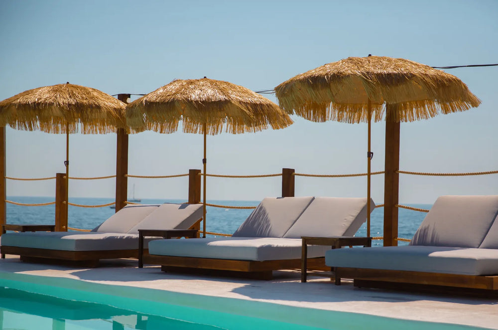 Ligbedden en rieten parasols aan zee bij Toy Room Beach Club Malta